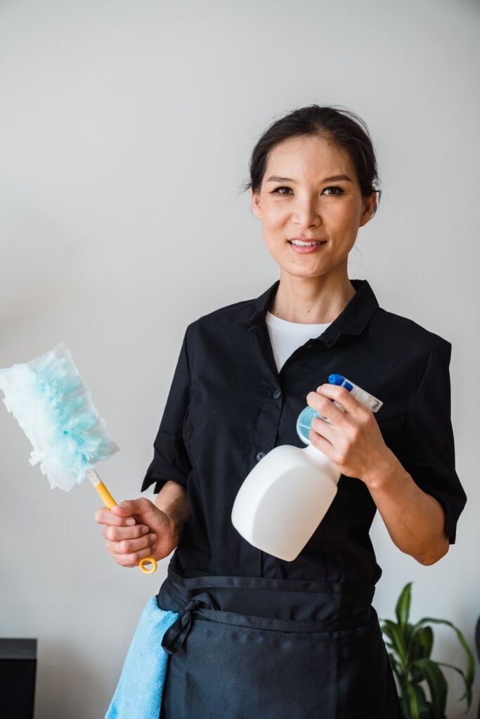 Diarista segurando borrifador de produto de limpeza