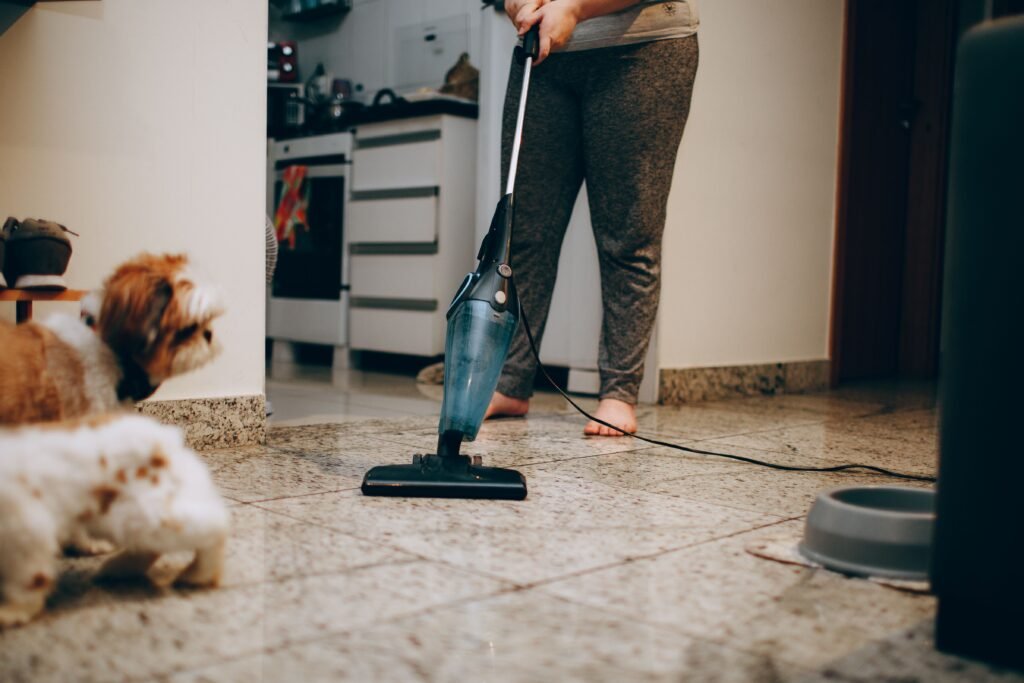 Pessoa limpando o piso da casa com espanador