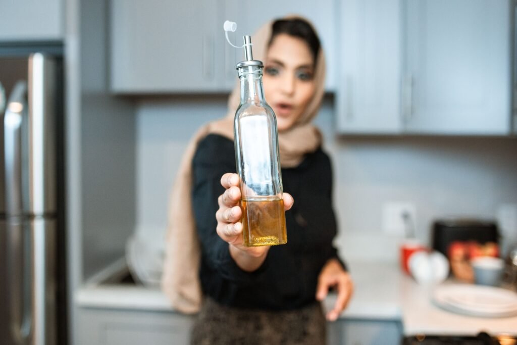 Pessoa utilizando óleo de cozinha durante o preparo de alimentos